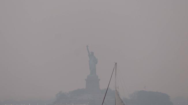 La Estatua de la Libertad, envuelta en una neblina rojiza como resultado de los incendios forestales canadienses.