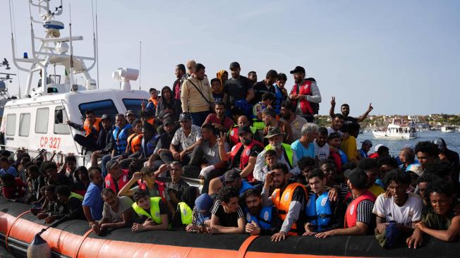 Migrantes llegan en pequeñas embarcaciones al puerto de Lampedusa, en Italia.