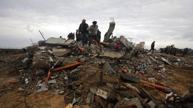 Palestinos buscan cuerpos tras los ataques aéreos israelíes en Deir Al Balah, Franja de Gaza.