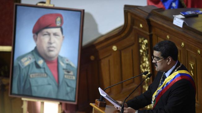 Nicolás Maduro presidente de Venezuela junto a un retrato de Hugo Chávez.