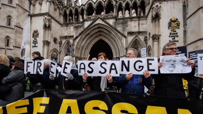 Activistas a favor de Assange protestan frente a los Tribunales Reales de Justicia.