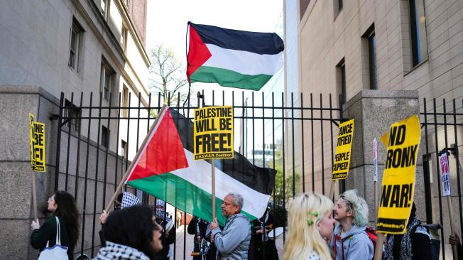 Partidarios pro-palestinos ondean banderas frente a la entrada de la Universidad de Columbia.