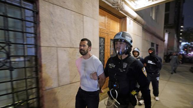 Agente de la policía detiene a un estudiante en la Universidad de Columbia.