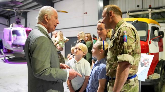 El rey Carlos III (izq.) de Gran Bretaña se reúne con miembros del personal y sus familias en el Centro de Aviación del Ejército en Middle Wallop, Inglaterra.