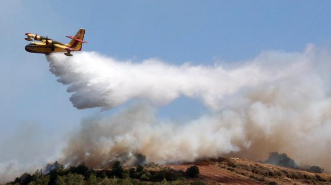Keratea (Greece), 30/06/2024.- A firefighting aircraft drops water during efforts to put out a wildfire in Keratea, southeast of Athens, Greece, 30 June 2024. Firefighting forces have been reinforced and are still fighting the blaze in Keratea, with more than 140 firefighters and 17 firefighting aircraft taking part in the operations, Civil Protection sources said. According to the civil protection services, the fire does not have a single front, but four separate sources of flames that the firefighters are working to extinguish simultaneously with constant water drops from the aircraft on each blaze. So far, six settlements have been safely evacuated and 52 people who were trapped have been brought to safety, with police taking over the evacuation of dozens of homes. (incendio forestal, Grecia, Atenas) EFE/EPA/ORESTIS PANAGIOTOU