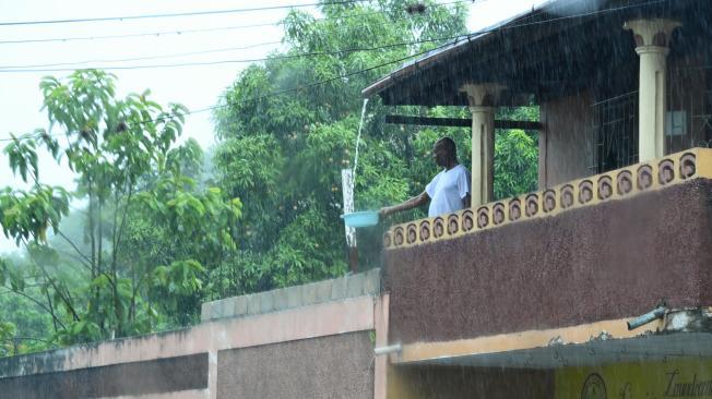 Un hombre llena un balde con agua de lluvia desde el balcón de su casa este miércoles, en Kingston (Jamaica). La pared del centro de Beryl, un peligroso huracán de categoría 4, 'cepilla' la costa sur de Jamaica y se espera que el sistema se acerque esta noche a las Islas Caimán en dirección a la Península de Yucatán (México), informó el Centro Nacional de Huracanes (NHC) de Estados Unidos.