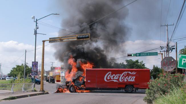 A truck on fire is seen on the streets of Culiacan, Sinaloa State, Mexico, on September 11, 2024. Elements of Mexico's National Guard were deployed in the state of Sinaloa, in the northwest of the country, amid an escalation of violence that authorities attribute to internal struggles within the Sinaloa cartel following the capture of its leader, Ismael "Mayo" Zambada. (Photo by Ivan MEDINA / AFP)