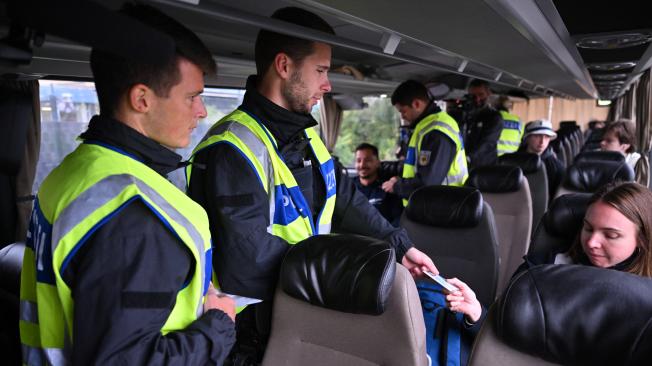 Agentes de policía alemanes controlan los documentos de identidad de los pasajeros de un autobús en la frontera entre Alemania y Francia.