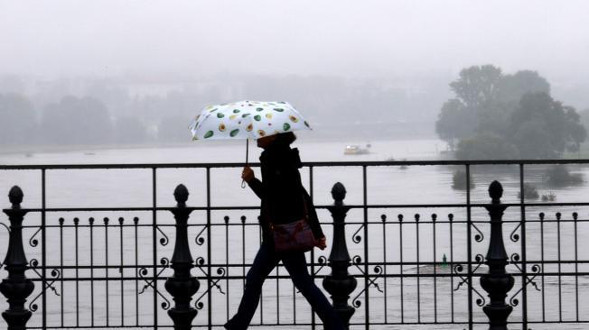 Un peatón camina sobre un puente con el río Elba crecido al fondo, Dresde, Sajonia, Alemania, el 16 de septiembre de 2024.