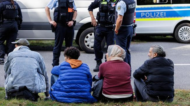 Un grupo de migrantes espera a un lado de la carretera mientras son controlados por agentes de la Policía Federal alemana (Bundespolizei) cerca de Forst, en el este de Alemania.