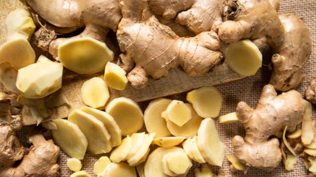 GiJengibrenger root and sliced ​​ginger fruit on a wooden table