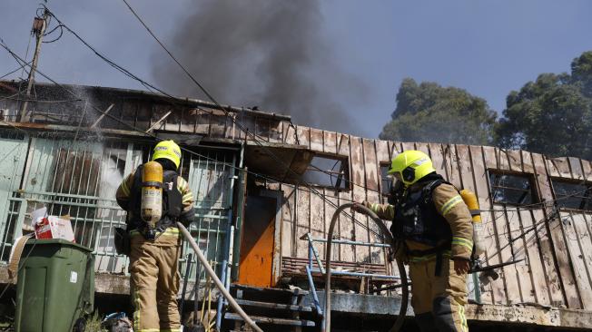 Bomberos israelíes luchan contra un incendio en Kiryat Shmona en el lugar donde cayó un cohete desde el sur del Líbano.