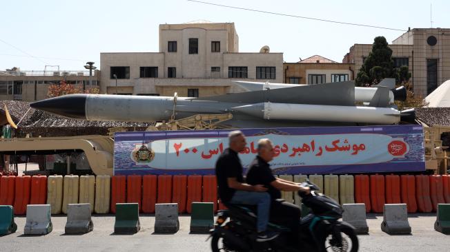 Tehran (Iran(islamic Republic Of)), 24/09/2024.- Iranians drive past next to the military equipment displayed at a street exhibition on the occasion of 'Defence Week', at the Baharestan Square in Tehran, Iran, 24 September 2024. Tension between Iran and Israel is growing up following Israel's attack on Hezbollah in southern Lebanon in the past 24 hours, as Iran warned Israel of the consequences of a wider regional war. Since the assassination of Hamas leader Ismail Haniyeh in the Iranian capital Tehran on 31 July 2024, Iranian leaders and officials have repeatedly stated that they will pursue a 'harsh punishment' against Israel in retaliation for Haniyeh's killing. (Líbano, Teherán, Hizbulá/Hezbolá) EFE/EPA/ABEDIN TAHERKENAREH