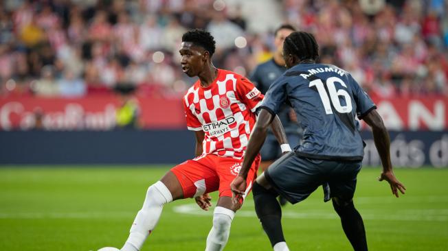 El delantero colombiano del Girona Yáser Asprilla (i) disputa un balón con el defensa ghanés del Rayo Abdul Mumin (d) durante el partido de la jornada 7 de LaLiga entre Girona FC y Rayo Vallecano, este miércoles en el estadio Municipal de Montilivi, en Girona.EFE/ David Borrat