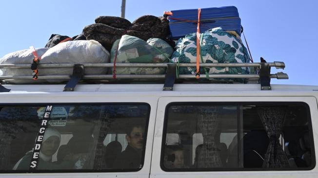 Personas que huyen del sur del Líbano viajan con sus pertenencias por la carretera de Khaldeh en dirección a Beirut.