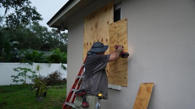 Un residente tapa sus ventanas con tablas en Palm Harbor, Florida, antes de la llegada prevista del huracán Milton a mitad de semana el 6 de octubre de 2024.