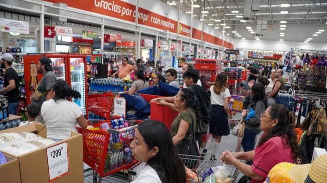 La gente hace cola para comprar comestibles en una tienda antes de la llegada del huracán Milton.