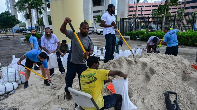 Habitantes de algunas zonas de Florida guardan arena en costales para proteger sus viviendas.