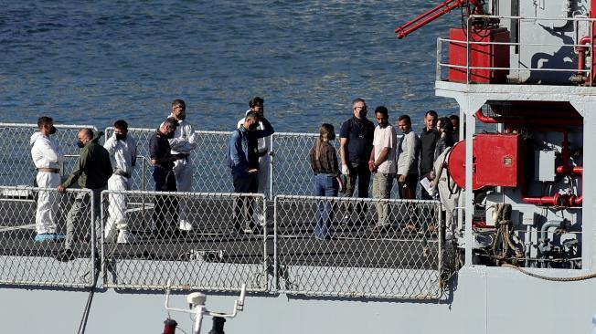 Un barco de la Armada con migrantes interceptados en aguas italianas llega al puerto de Shengjin, en Albania.