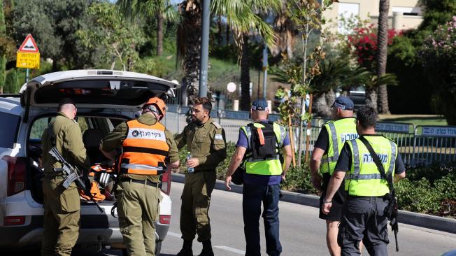 Miembros de las fuerzas de seguridad israelíes caminan por una calle que conduce a la residencia del primer ministro Benjamin Netanyahu en Cesarea.