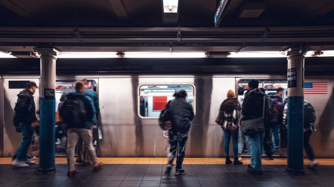 Crowd of people in a NYC subway station waiting for the train at rush hour.