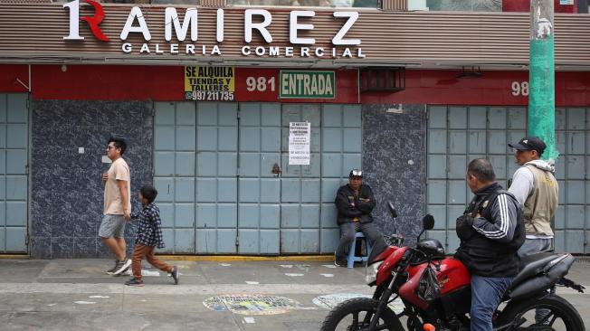 Personas reaccionan junto a un local comercial cerrado durante un paro convocado por gremios de transporte y comercio, este miércoles, en la ciudad de Lima (Perú). Varios mercados en Lima y otras ciudades de Perú amanecieron cerrados este miércoles y el transporte público funcionaba al mínimo, en el inicio de un paro convocado por diferentes gremios de esos sectores para protestar contra la ola de sicariato y extorsiones que azota el país. EFE/ Paolo Aguilar