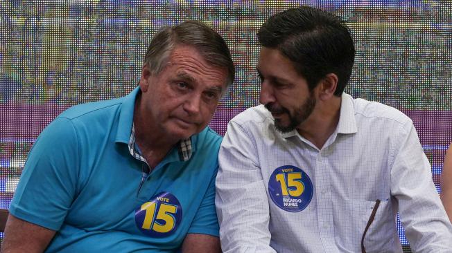 El candidato a la alcaldía de Sao Paulo, Ricardo Nunes (d), y el expresidente de Brasil Jair Bolsonaro charlan durante un acto de campaña.