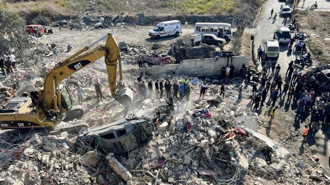 Rescatistas y residentes se reúnen en el lugar objetivo de un ataque aéreo israelí en Sarafand, sur del Líbano, el 30 de octubre de 2024.