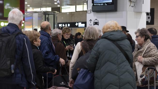 Varios pasajeros esperan en la Estación de Sants de Barcelona después de que el servicio de Rodalies de Cataluña ha quedado suspendido este lunes por la mañana en todo el territorio como consecuencia de las fuertes lluvias, que han obligado a Protección Civil de la Generalitat a emitir varios avisos. EFE/Marta Pérez