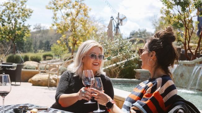 Female friends having food and wine together in a restaurant in California.