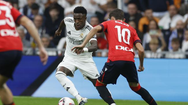 El delantero brasileño del Real Madrid Vinicius Jr y el centrocampista de Osasuna Aimar Oroz, durante el partido de la jornada 13 de LaLiga entre Real Madrid y Osasuna, este sábado en el estadio Santiago Bernabéu en Madrid.-EFE/ Javier Lizón