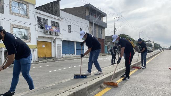 Funcionarios y comunidad limpiando una de las calles de Barranquilla.