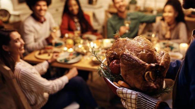 Los estadounidenses se reúnen con amigos y familiares para compartir un gran banquete.