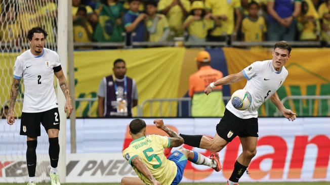 Bruno Guimarães (c) de Brasil disputa el balón con Manuel Ugarte (d) de Uruguay este martes, en un partido de las eliminatorias sudamericanas para el Mundial de 2026 entre Brasil y Uruguay, en el estadio Arena Fonte Nova en Salvador (Brasil). EFE/ Isaac Fontana