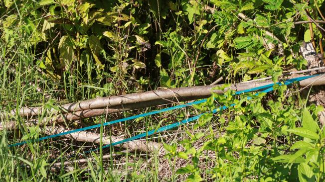 Una cinta verde utilizada como advertencia de minas terrestres junto a una carretera rural en Myanmar.