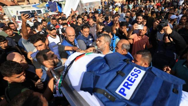 Periodistas, familiares y amigos rezan ante el cuerpo del periodista de la televisión palestina Mohamed Abu Hatab y 11 miembros de su familia el día después de su muerte en Gaza