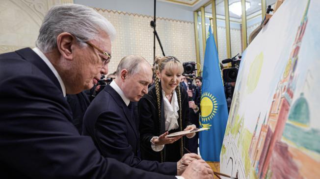 El presidente ruso Vladimir Putin y el presidente kazajo Kassym-Jomart Tokayev dibujan una pintura durante una ceremonia de bienvenida en el Aeropuerto Internacional Nursultan Nazarbayev, en Astana, Kazajstán, el 27 de noviembre de 2024.