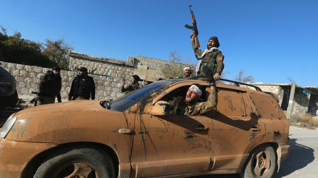 Combatientes antigubernamentales celebran en una calle de Maaret al-Numan, en la provincia noroccidental siria de Idlib.