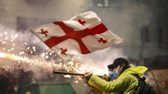 -FOTODELDIA- Tbilisi (Georgia), 01/12/2024.- Un manifestante opositor lanza unos fuegos artificiales a la policía durante una manifestación en frente del parlamento en Tbilisi, Georgia. Georgia declaró ilegales las protestas opositoras contra la congelación hasta 2028 de las negociaciones para el ingreso de la nación caucásica en la Unión Europea (UE) que sacuden la capital georgiana por segunda jornada consecutiva y comienza las detenciones.EFE/ David Mdzinarishvili