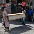 Dos personas cargan un cajón para recoger el cuerpo de una persona en la calle este miércoles en Puerto Príncipe (Haití). Al menos siete cadáveres aparecieron este miércoles en las calles de Petion-ville, en las colinas de la capital de Haití, dos días después de que al menos otras quince personas fueran encontradas muertas en la misma zona.