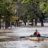 -Una mujer acompañada de un niño conduce una embarcación por una calle inundada este lunes en Concordia (Argentina).