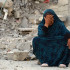 Una mujer palestina hace gestos sentada sobre los escombros de bombardeos israelíes anteriores, en Jan Yunis, en el sur de la Franja de Gaza.