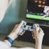 Girl playing a video game console. Game is football. Joystick in hands. Selective focus
