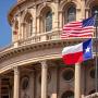 Las banderas de Texas y de Estados Unidos al pie de un edificio.