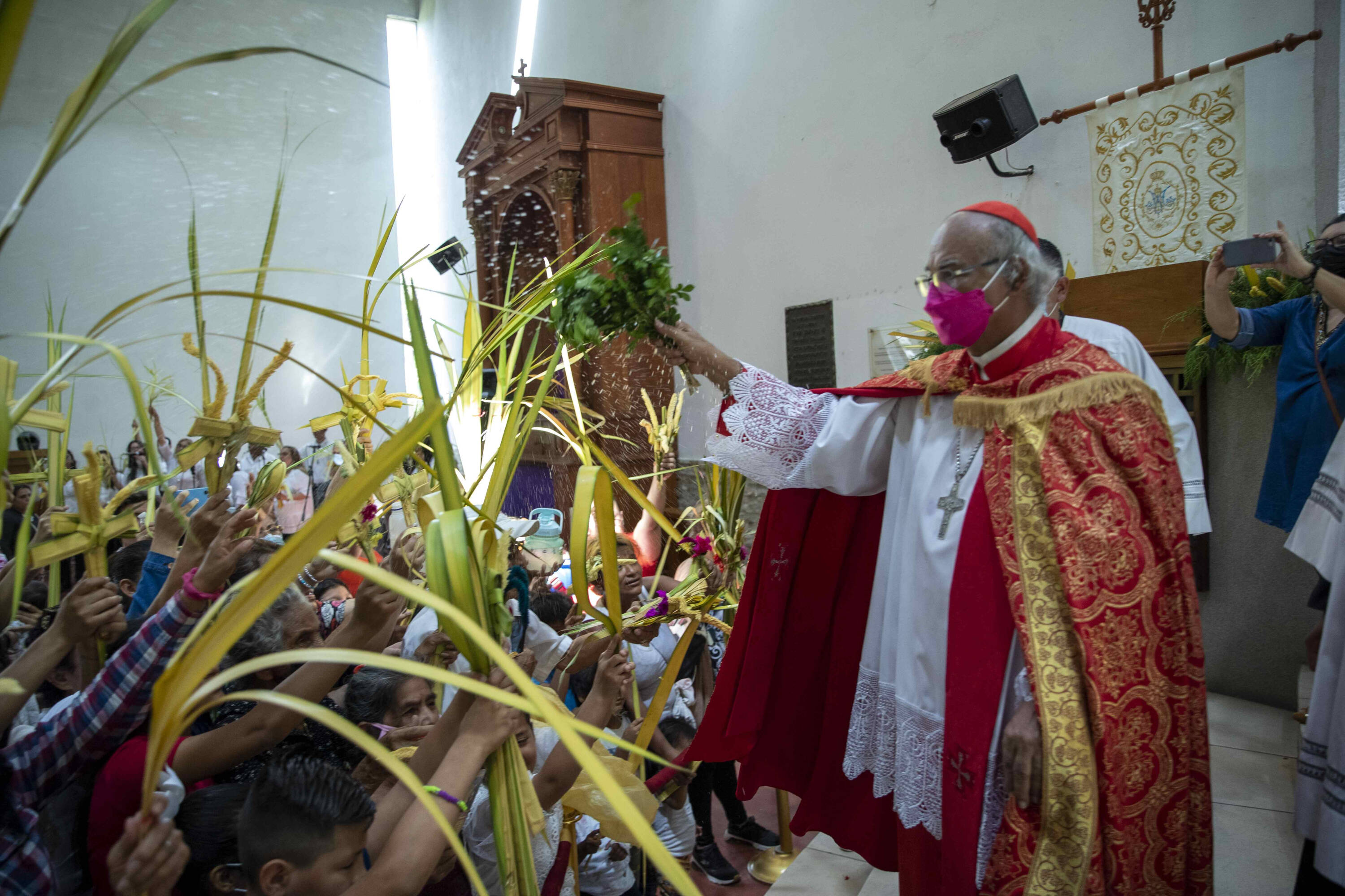 El cardenal Leopoldo Brenes bendice ramos de palmas durante la misa del Domingo de Ramos en el inicio de las festividades religiosas en Managua (Nicaragua).