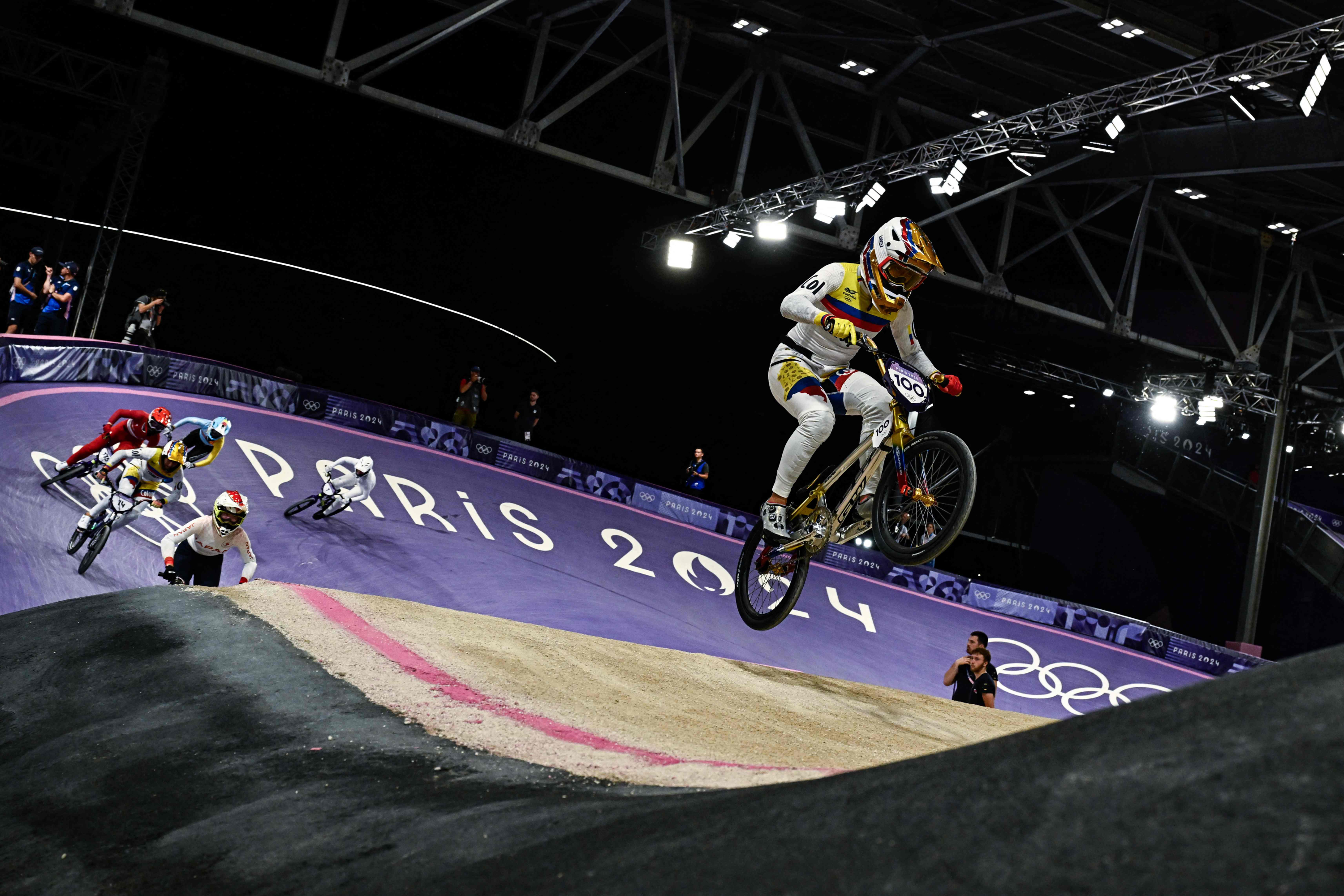 Colombia's #100 Mariana Pajon Londono leads riders in the last chance race of the Women's Cycling BMX Racing quarterfinals during the Paris 2024 Olympic Games in Saint-Quentin-en-Yvelines, on August 1, 2024. (Photo by JULIEN DE ROSA / AFP)