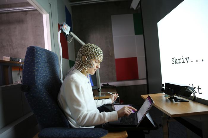 El estudiante se somete a un EEG mientras escribe a mano y a máquina.