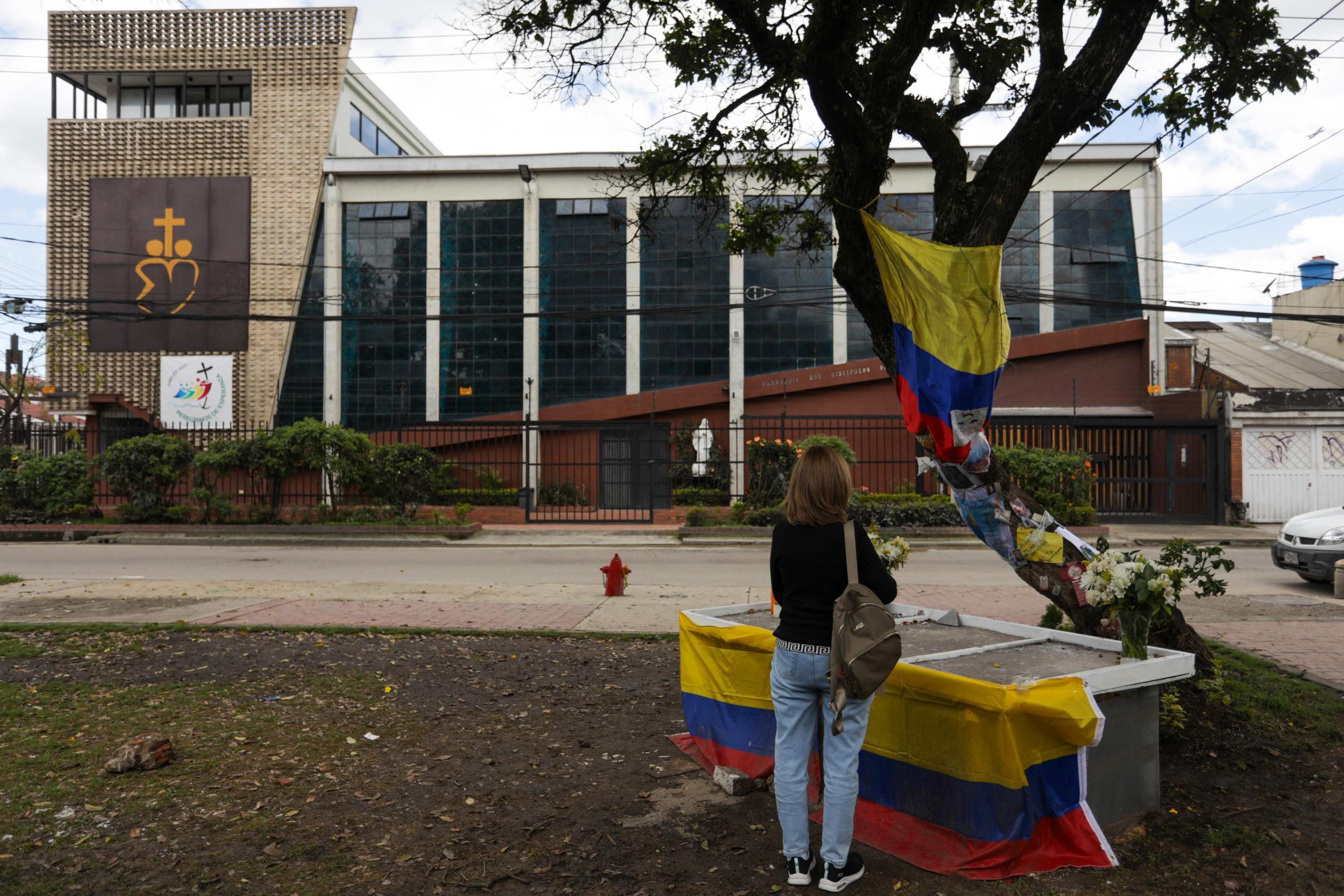 UNA MUJER SE Detiene Frente al Altar que se Hizo en el Lugar del Atentado.
