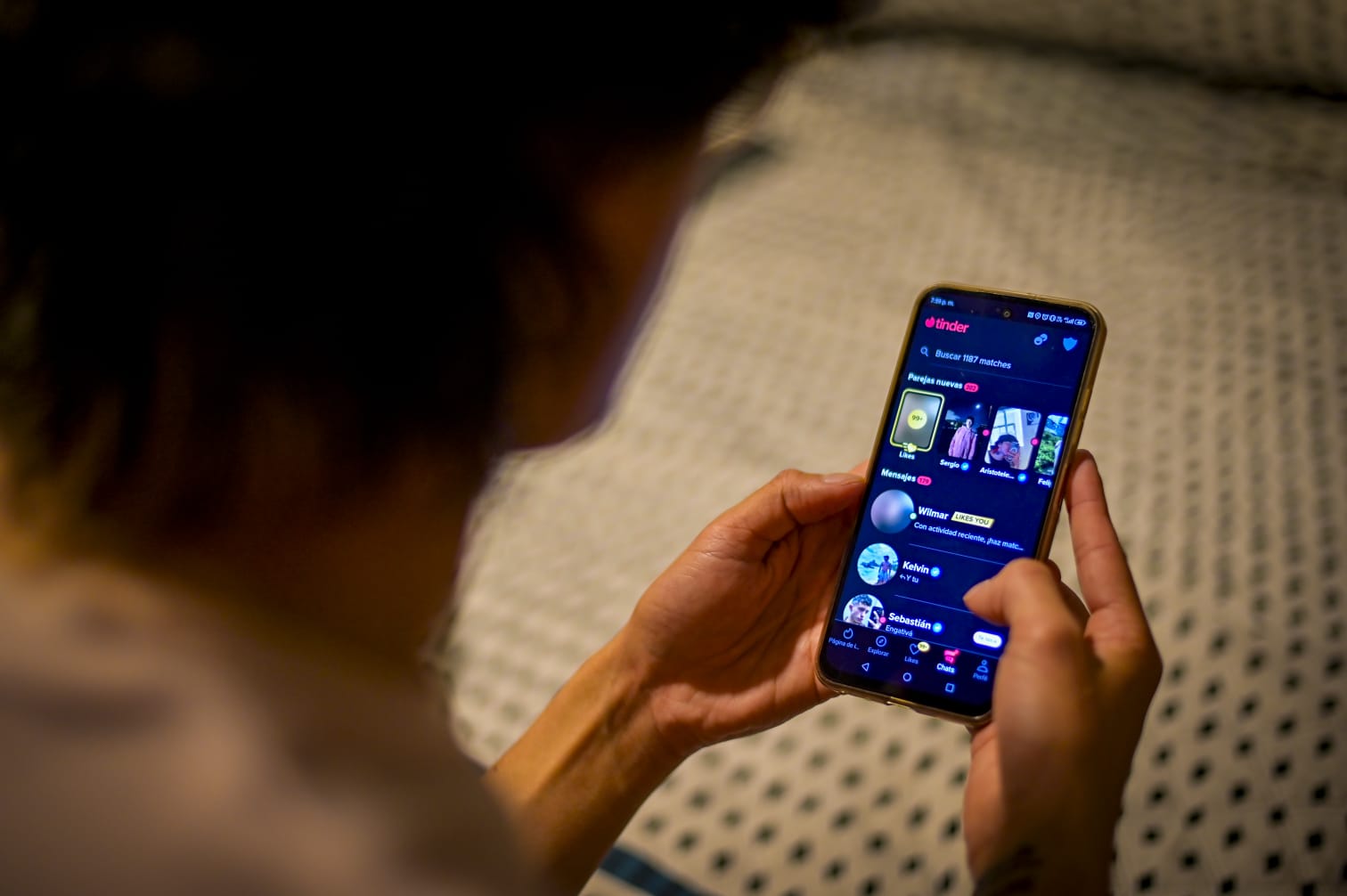 UNA USUARIA Revisa Perfiles en una aplicación de citas. Las autoridadas alertan Sobre perfiles falsos que simulan ser reales.