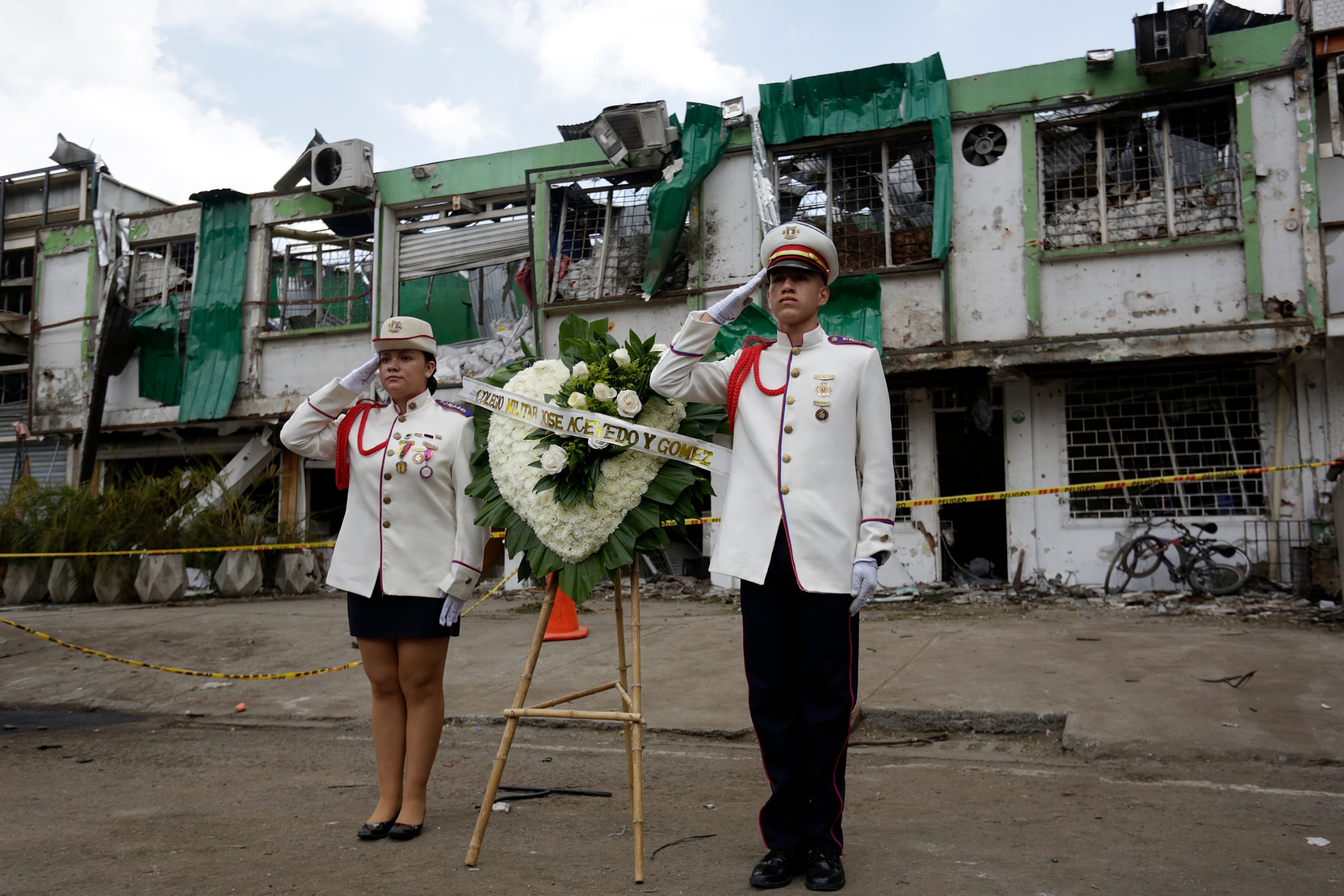 Conun Minuto de Silencio, Estudiantes del Colegio Militar José Acevedo y Gómez Les Rindieron Un Homenaje A Las Víctimas Fatales en El Lugar del Atentado en Cali. Al Fondo se Observa la Destrución Que Dejó El Ataque.